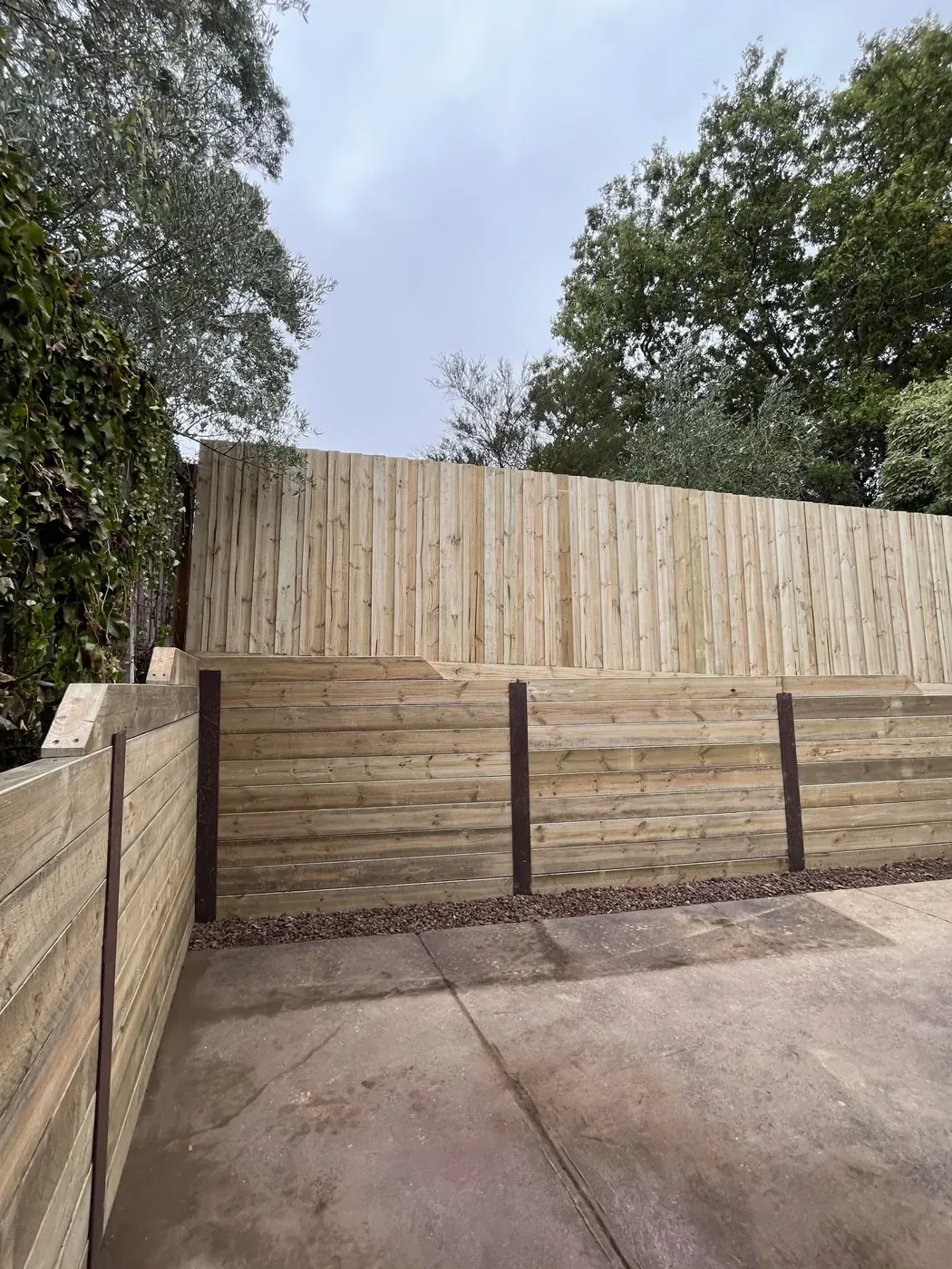 Timber sleeper retaining wall with paved area